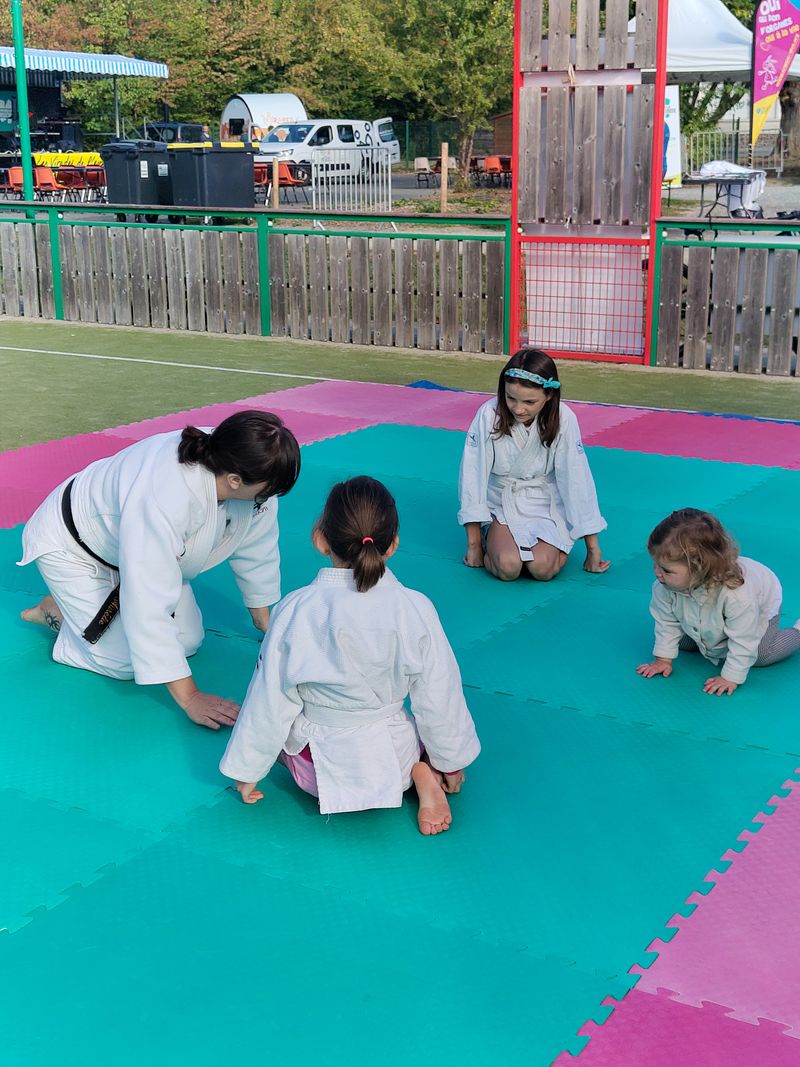 la scène montre un professeur de judo donnant les instruction aux enfants pour faire les chutes avant